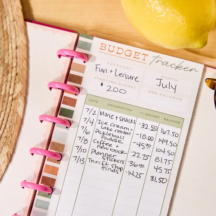 A person writing a detailed budget in a planner