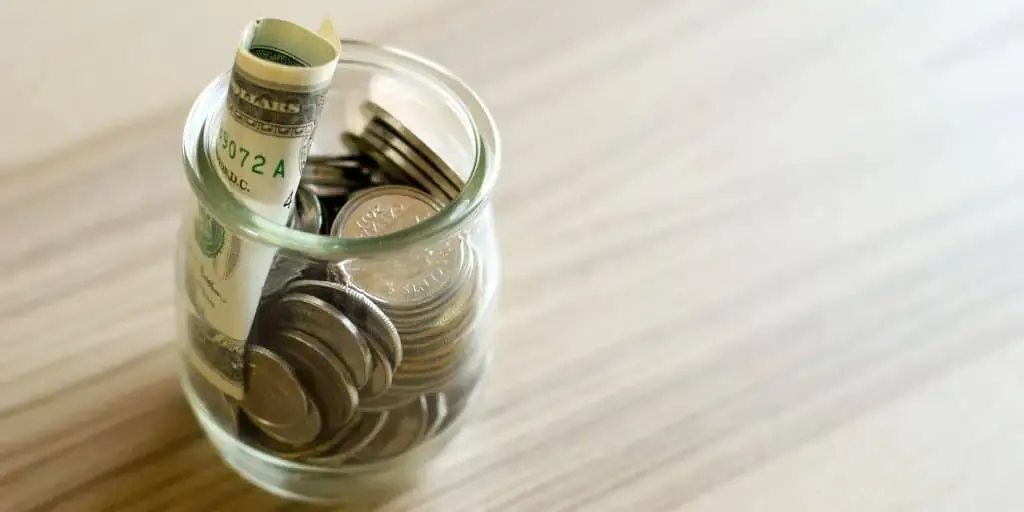 Several glass jars labeled with different savings goals like 'Vacation' and 'Car Maintenance'